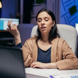 Businesswoman using earbuds in the course of online call