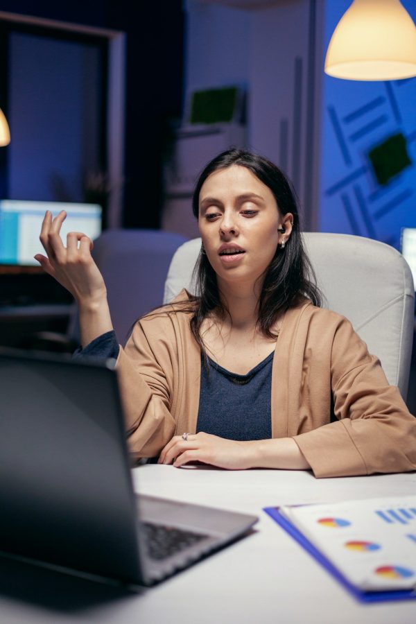 Businesswoman using earbuds in the course of online call